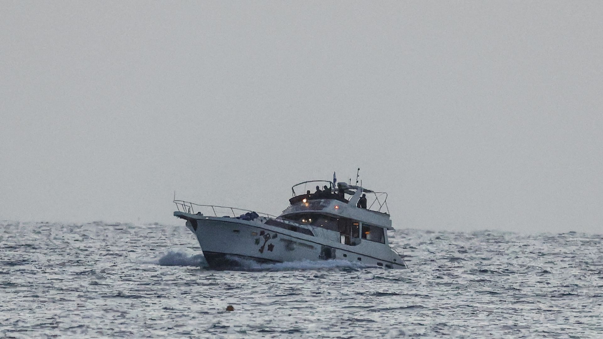 A boat bearing symbols of one of the vessels belonging to the Gaza-bound aid flotilla (L), intercepted by the Israeli navy, is motored towards the Israeli port of Ashdod, on May 19. /Jack Guez/AFP
