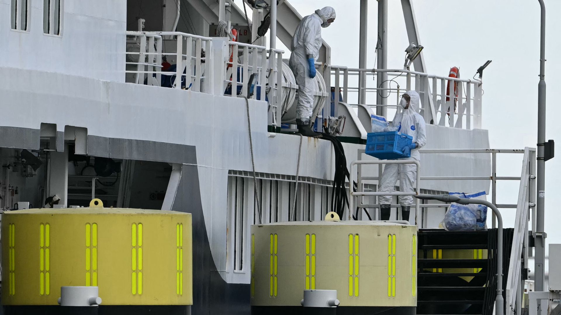 Workers in protective hazmat suits disembark from the Dutch Hantavirus-hit cruise ship MV Hondius at the port of Rotterdam this month. /Nicolas Tucat/AFP
