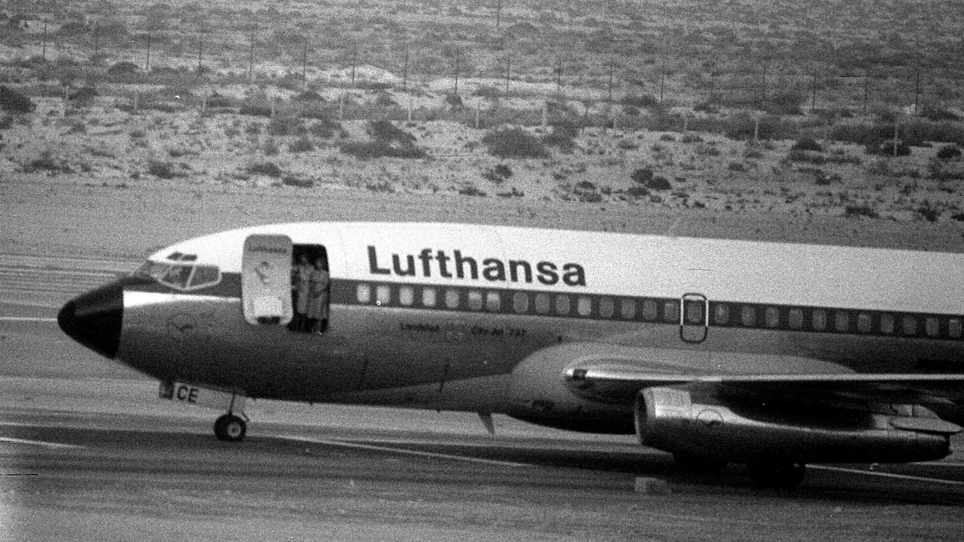 On October 15, 1977, two stewardesses stand in the open front door of a hijacked Lufthansa jetliner Landshut taken by the Red Army Faction, at an airfield in Dubai. /Harry Koundakjian/AP