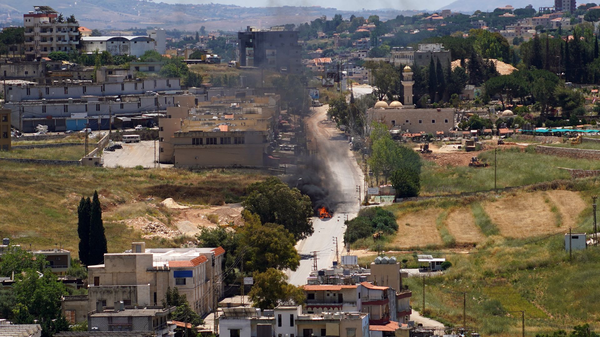 First responders attend to a burning vehicle targeted by an Israeli drone attack in the southern Lebanese city of Nabatieh on June. /Abbas Fakih/AFP
