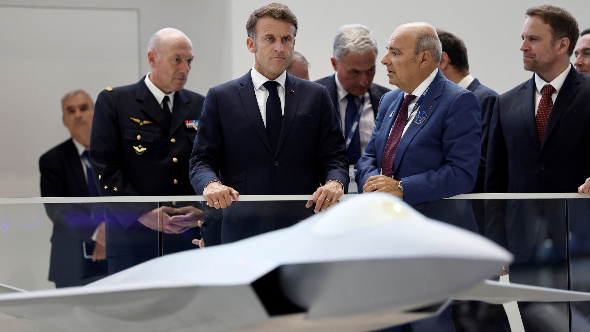 French President Emmanuel Macron, center, listens to Eric Trappier, Chairman and Chief Executive Officer of Dassault Aviation, center right, at the 55th International Paris Airshow at Le Bourget Airport near Paris, France, Friday June 20, 2025. /Benoit Tessier/Pool via AP
