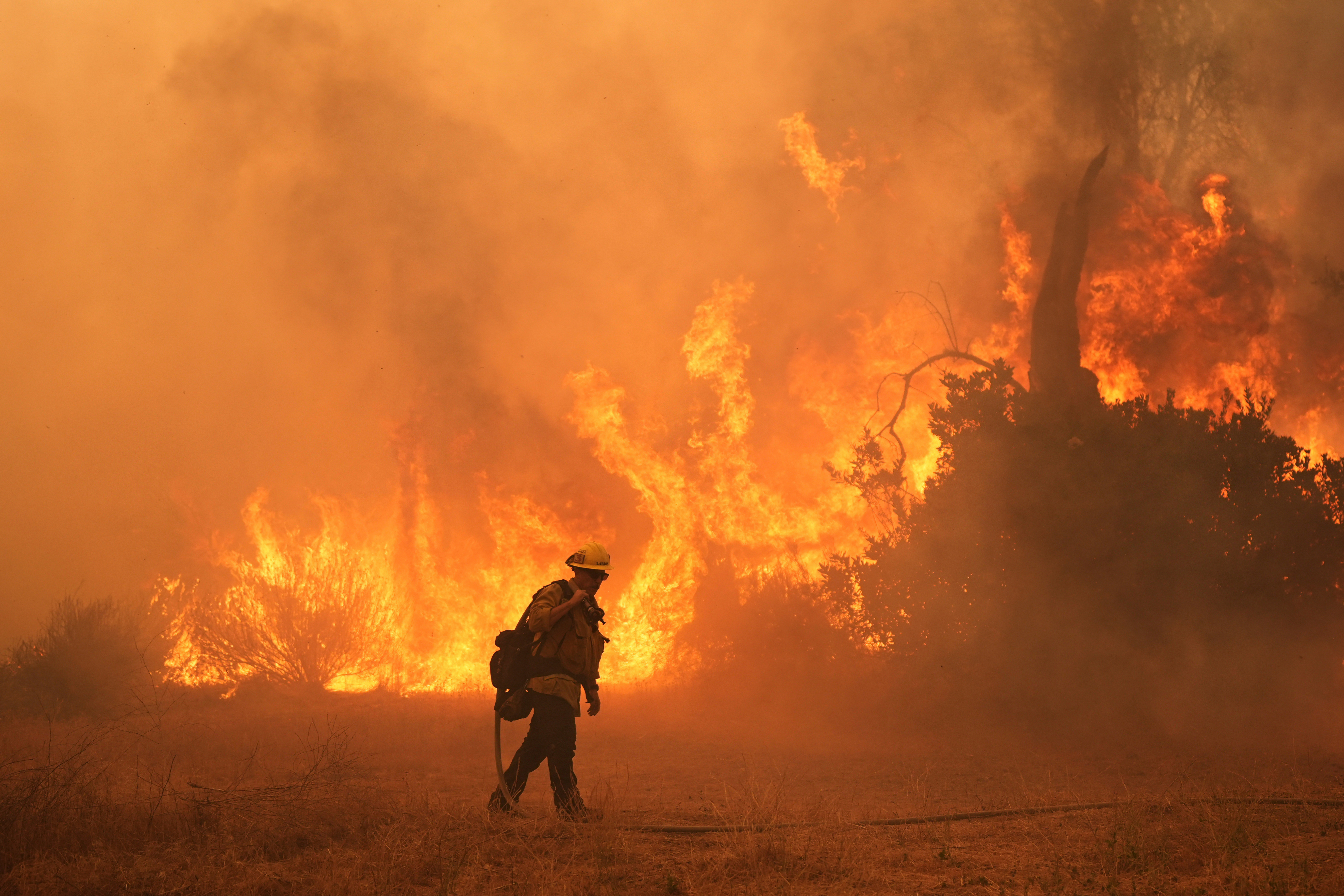 A firefighter battles the Canyon Fire on in Hasley Canyon, Calif.  /Marcio Jose Sanchez/AP