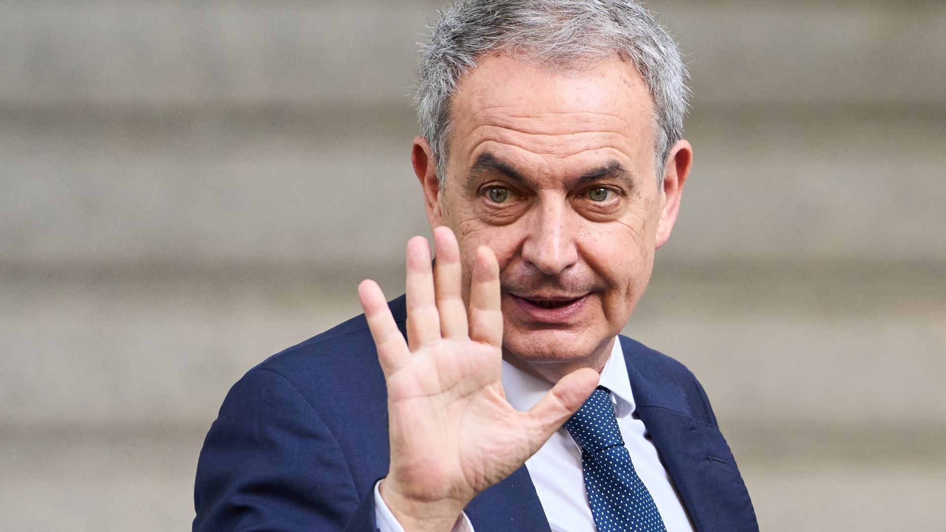 Spain's former prime minister José Zapatero waves to reporters outside the National Court in Madrid. He faces two separate probes into allegations of including influence-peddling and smuggling / AP.