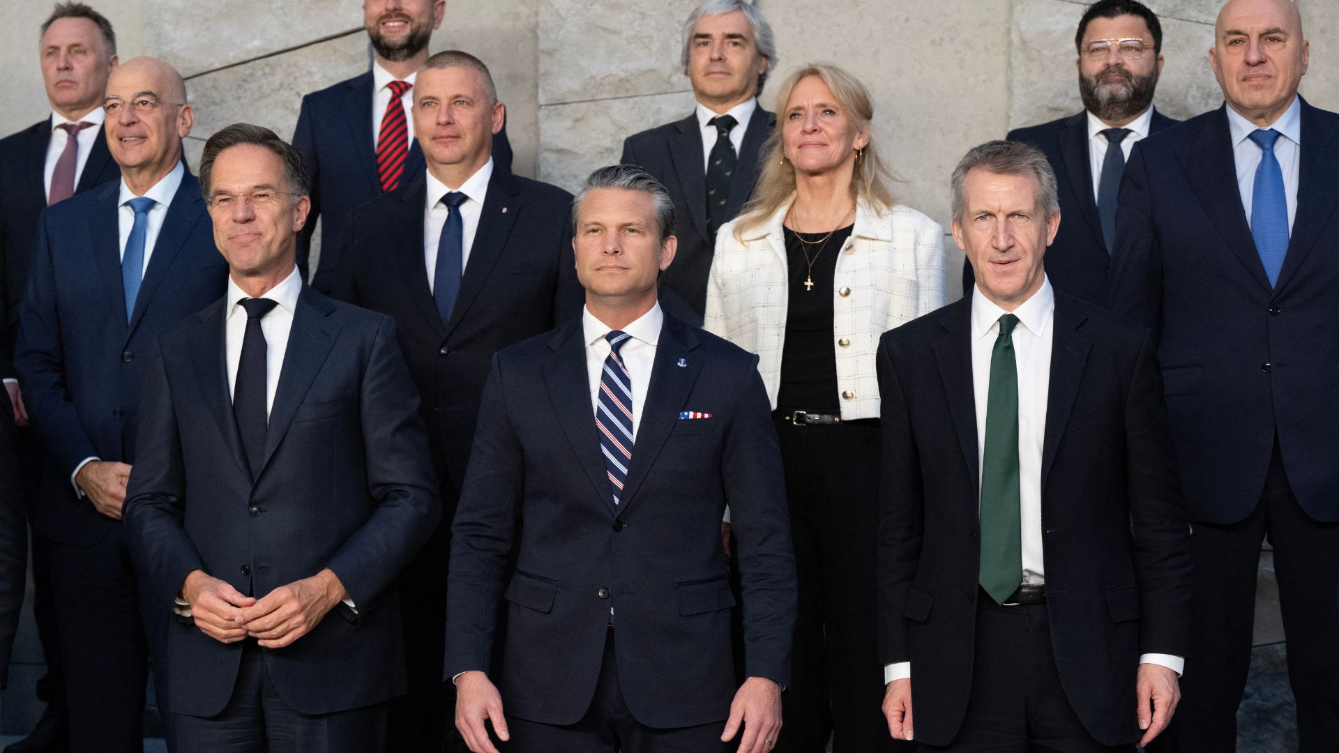 The US Secretary of War Pete Hegseth (bottom row, centre) stands alongside Nato Secretary General Mark Rutte (L) and the UK's new Defence Secretary Dan Jarvis (R) in Brussels. Hegseth lambasting Nato countries for their perceived lack of support for the US war in Iran, and their defense spending. / AP.