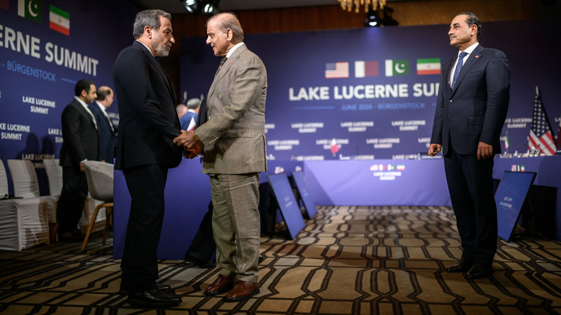 Iran's Foreign Minister Abbas Araghchi (L) shakes hands with Pakistan's Prime Minister Muhammad Shehbaz Sharif (C) next to Pakistan's Chief of Army Staff Field Marshal Asim Munir (R) at the Burgenstock luxury hotel complex overlooking Lake Lucerne, Switzerland. /Fabrice Coffrini/Pool/AFP