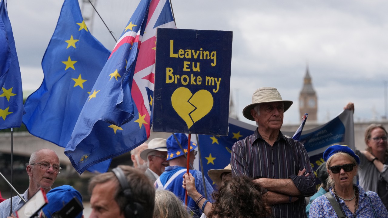 People wave flags during a National 'Rejoin the EU' march in central London. /Carlos Jasso/AFP