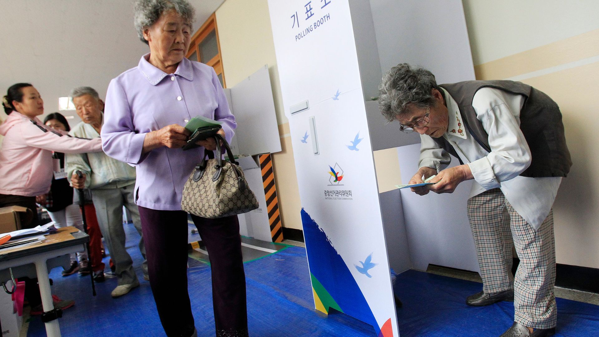 Elderly women wait to cast their ballots in local elections at a polling station in Nonsan, South Korea, 2014. /Ahn Young-joon/AP Photo
