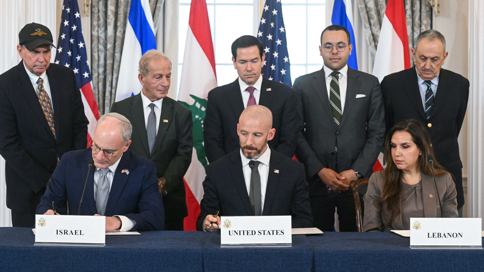US Secretary of State Marco Rubio (C, back) looks on as (L/R, front row) Israeli Ambassador to the US Yechiel Leiter, State Department Chief of Staff Daniel Holler, and Lebanese Ambassador to the US Nada Hamadeh sign a framework agreement in Washington DC on June 26, 2026. /AFP. 