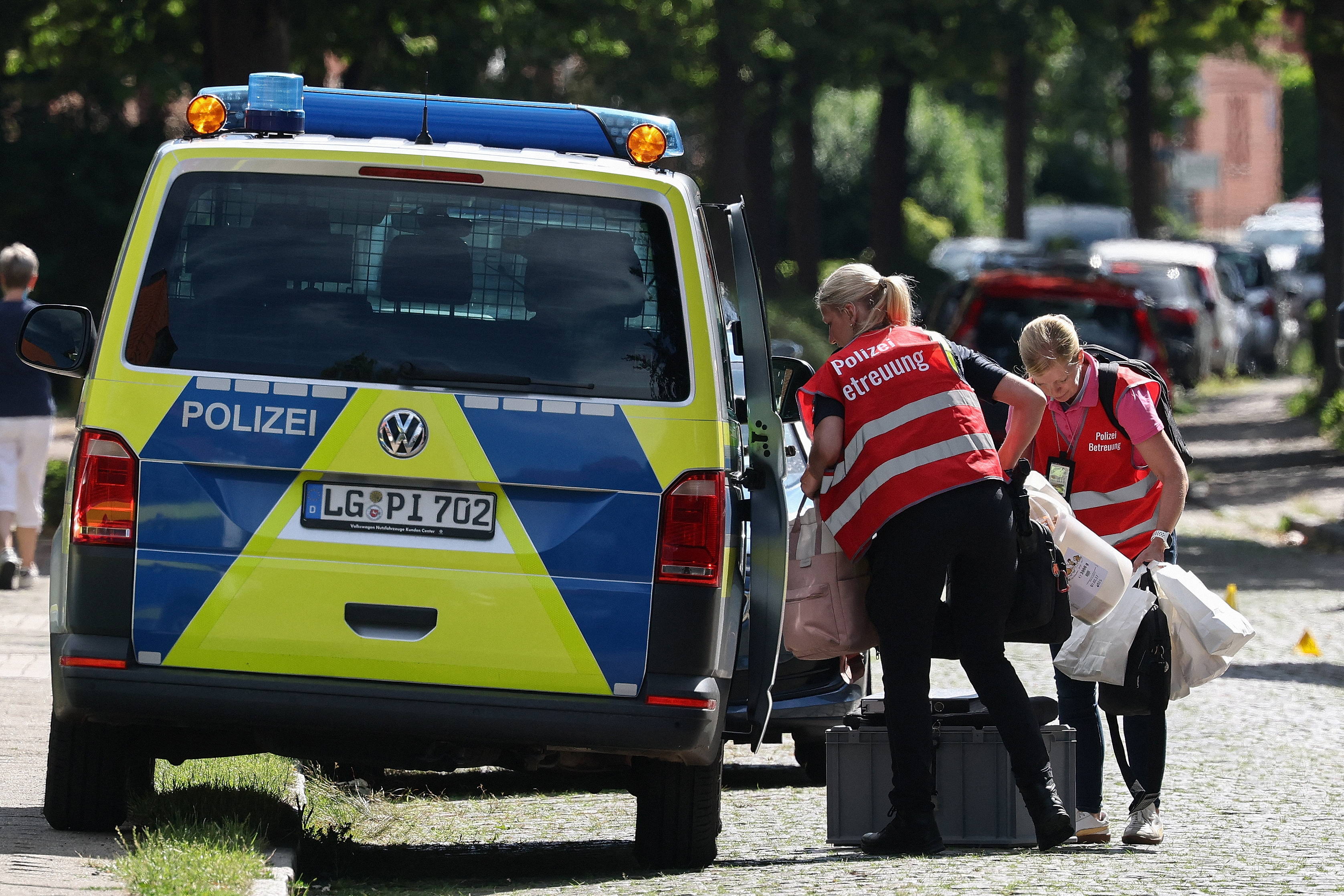 Police supervisors transport material near the scene of the deadly shooting. /Ibrahim Ot/AFP