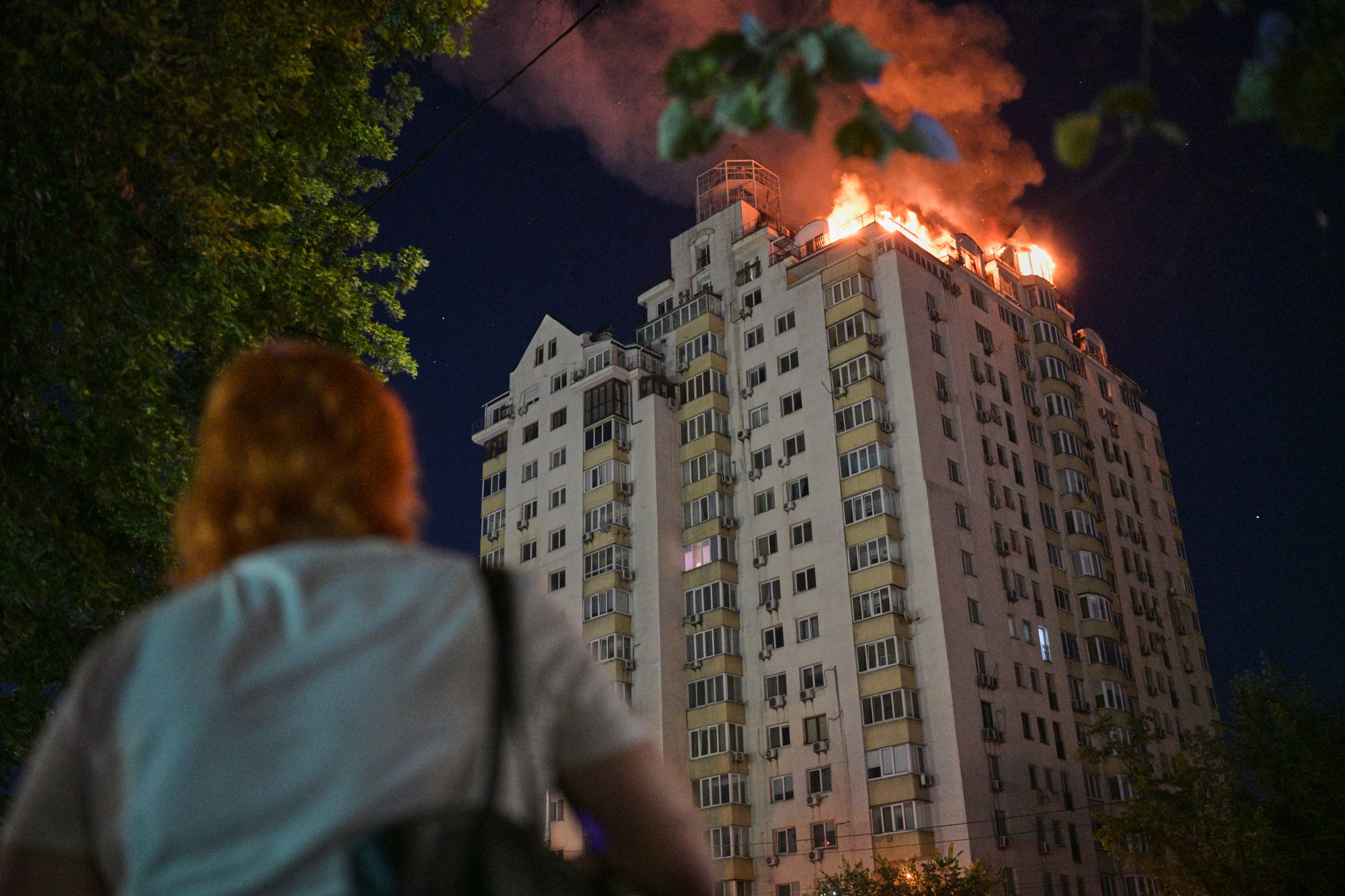 A woman looks at an apartment building burning after a Russian missile attack in Kyiv, Ukraine, Thursday, July 2, 2026. /Danylo Antoniuk/AP