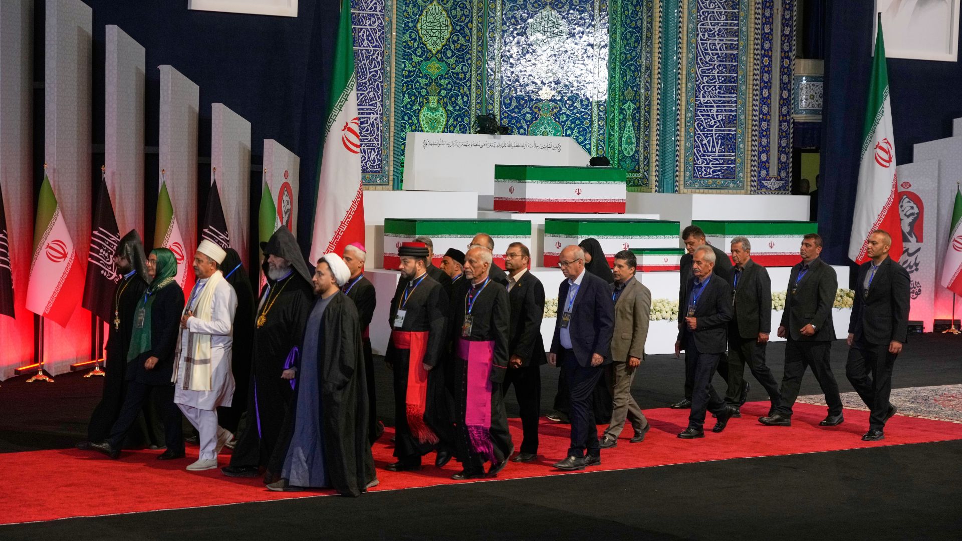 Iranian religious leaders walk with mourners past the coffins of slain Iranian Supreme Leader Ayatollah Ali Khamenei and members of his family at the Imam Khomeini Mosalla Grand Mosque in Tehran. /AP