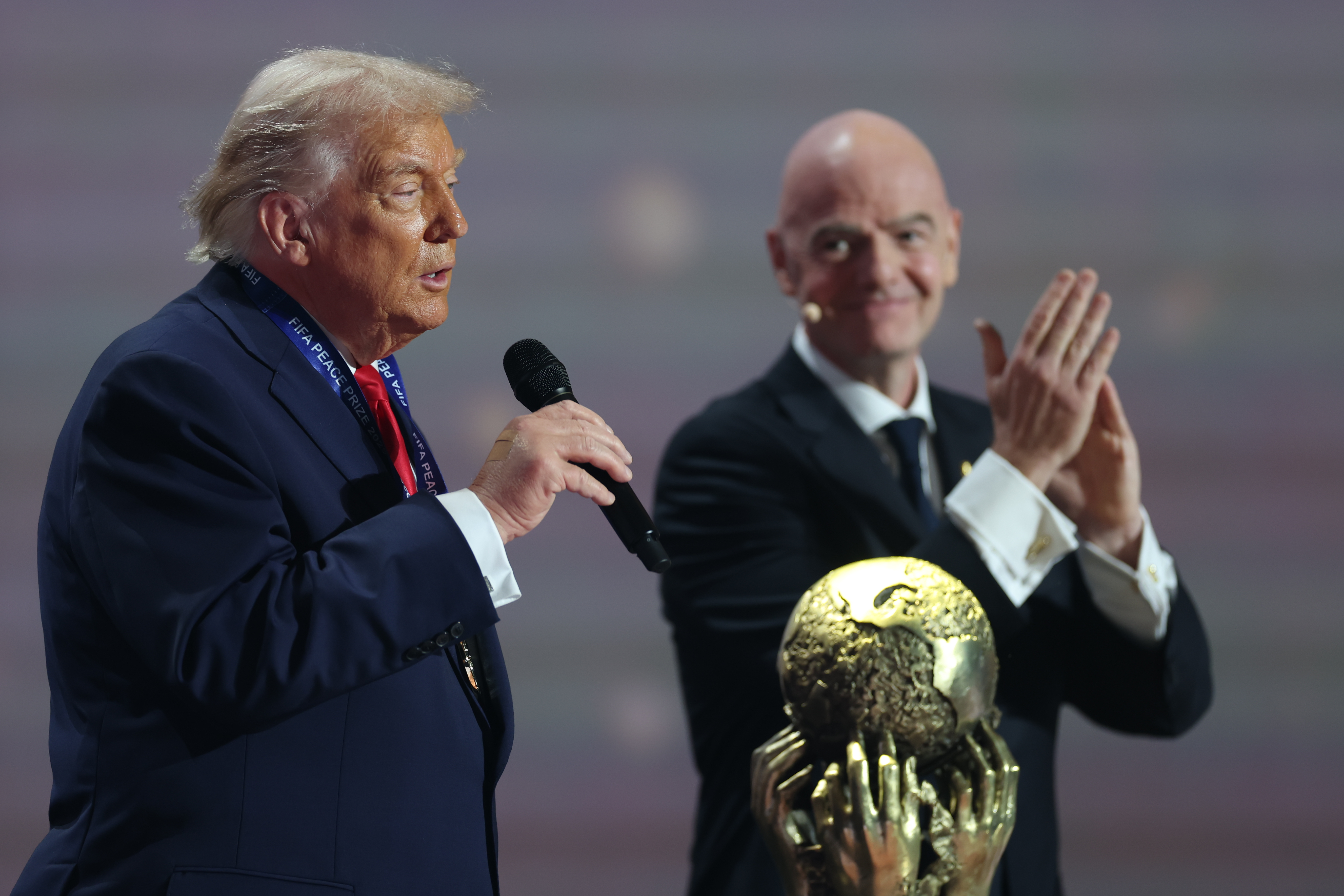 FIFA President Gianni Infantino (R) claps after giving President Donald Trump the FIFA Peace Prize in December. /Dan Mullan/Pool via AP