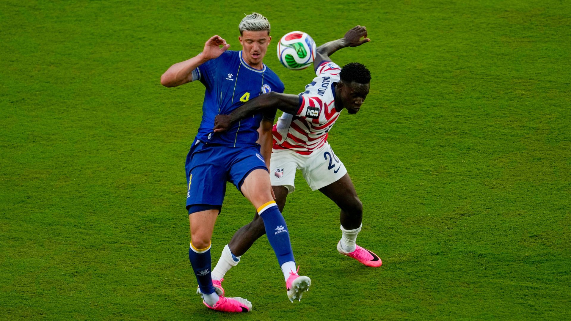 The foul that kicked off a political football: US striker Folarin Balogun (R) on Bosnia's Tarik Muharemovic last Wednesday. /Jeff Chiu/AP Photo