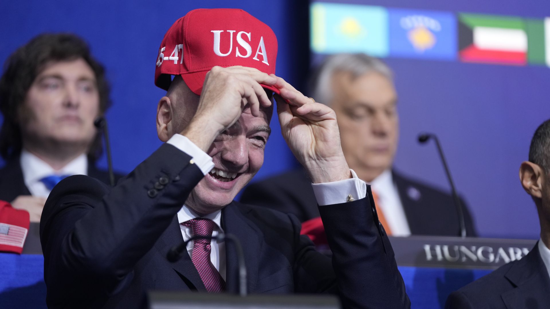 Infantino dons a Trump-red USA hat at the Board of Peace meeting in February. /Mark Schiefelbein/AP Photo
