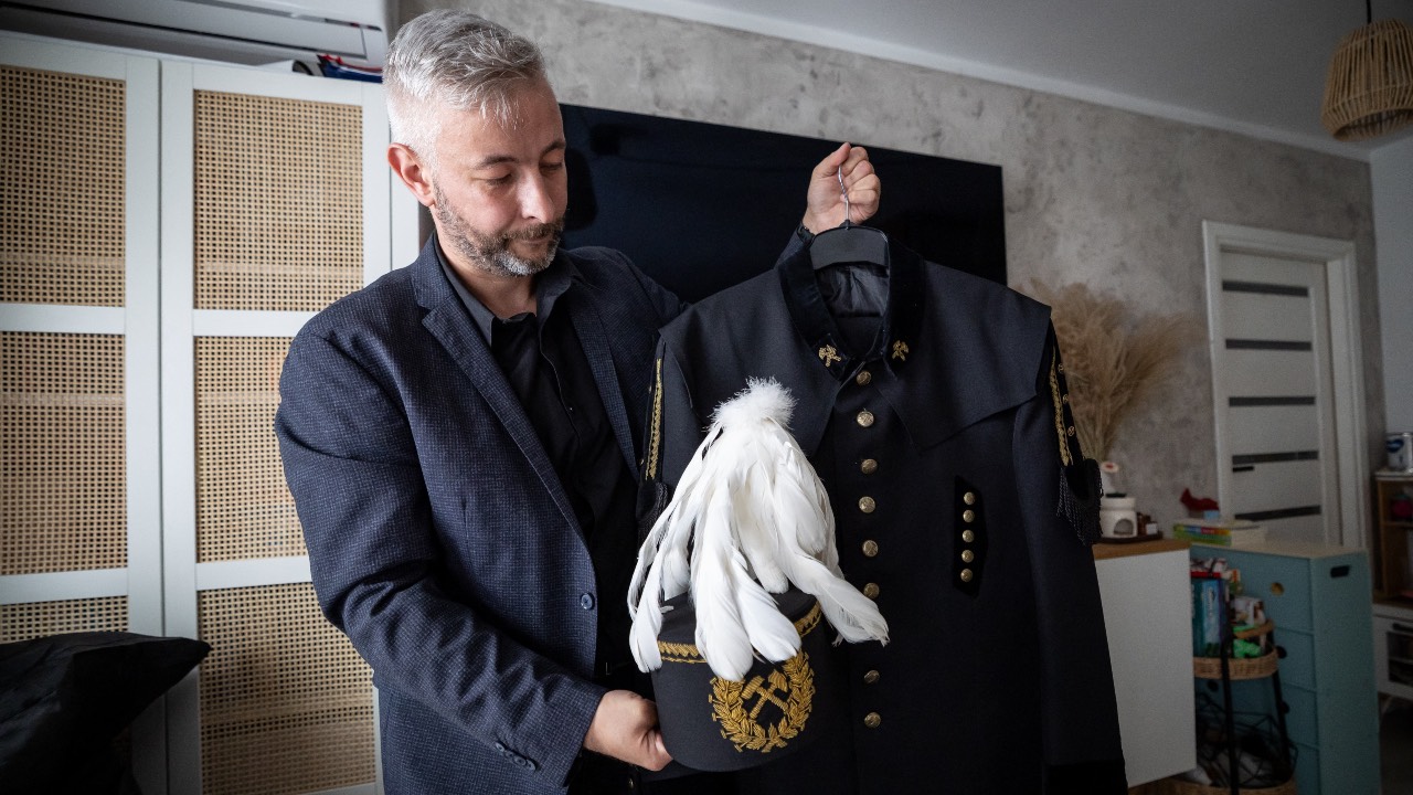 Grzegorz Witek, a miner with 14 years of experience who is taking part in a training programme to become a wind turbine technician, presents his ceremonial miner’s uniform at his apartment in Bytom, in the Silesia region of southern Poland. /Wojtek Radwanski/AFP