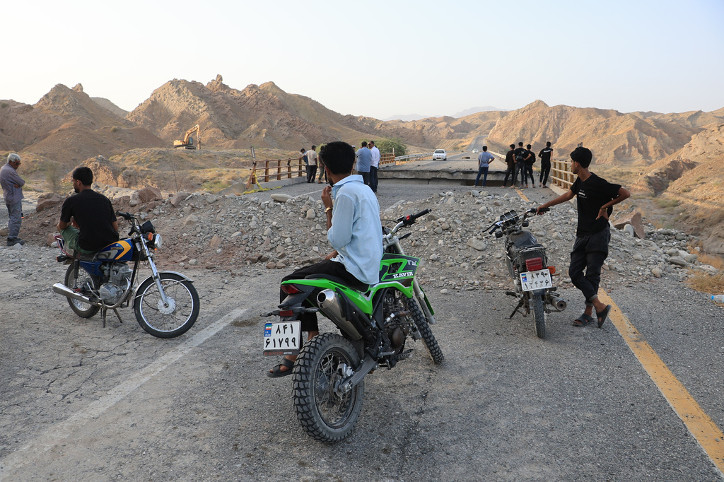 People stand on a bridge destroyed after a strike in Hormozgan province, southern Iran. /Amirhosein Khorgooi/Iranian Students' News Agency via AP