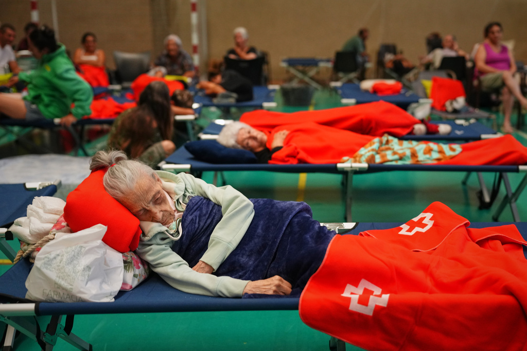 Residents spend the night at a sports center after being evacuated from their homes because of the threat of a wildfire in Cebreros, Ávila province, Spain, Friday, July 24, 2026. Manu Fernandez/AP