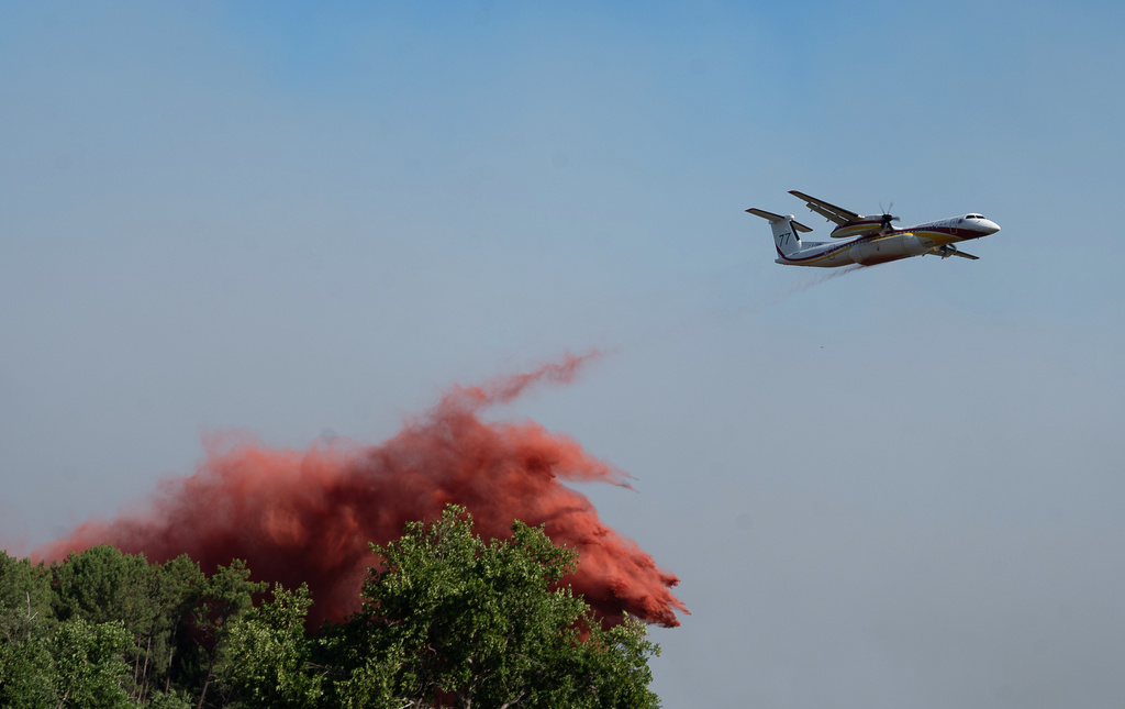 A water bomber drops water while fighting wildfires In Ares, western France, Friday July 24, 2026. /Caroline Blumberg/AP