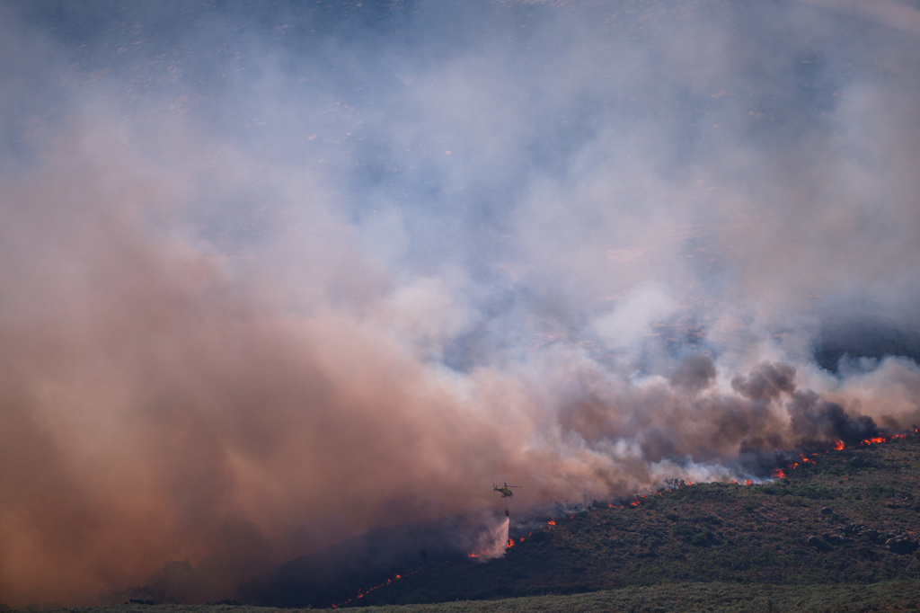 A firefighting helicopter drops water on the flames as a wildfire advances near Burgohondo, Ávila province, Spain, Friday, July 24, 2026. /Manu Fernandez/AP