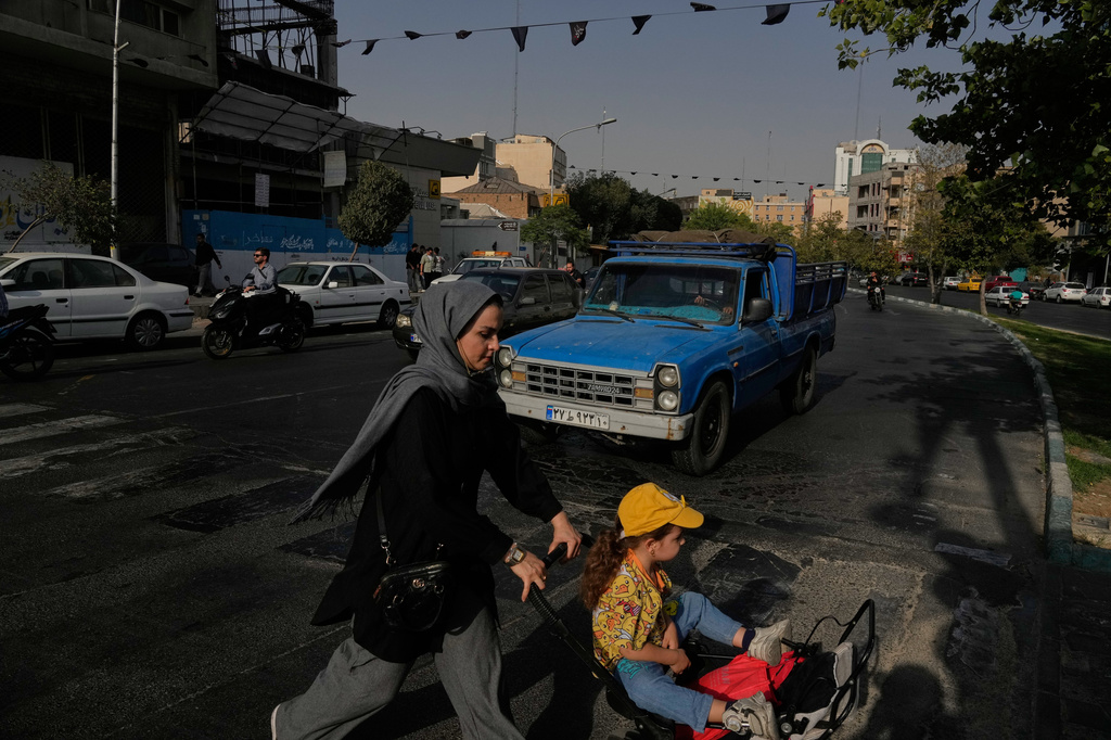 A woman crosses a street with a girl in downtown Tehran, Iran, Wednesday, July 22, 2026. /Vahid Salemi/AP