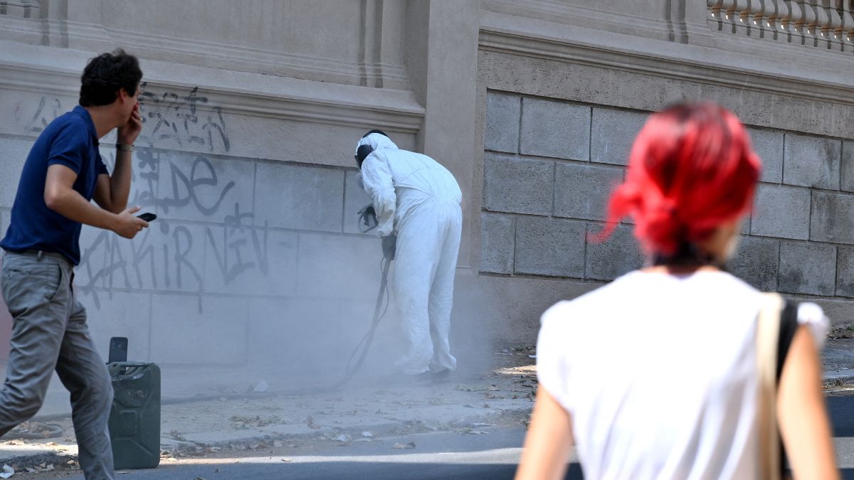 Tuveri uses a high-pressure sand-blaster to remove graffiti inch-by-inch. /AfP.