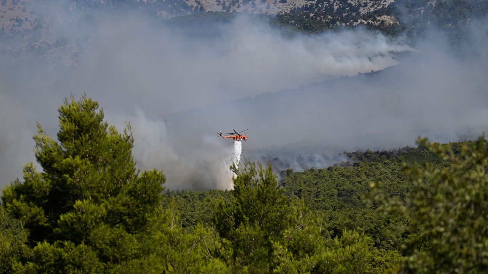 Firefighting helicopters can drop as much as 3,000 liters of water with every pass. /AP.