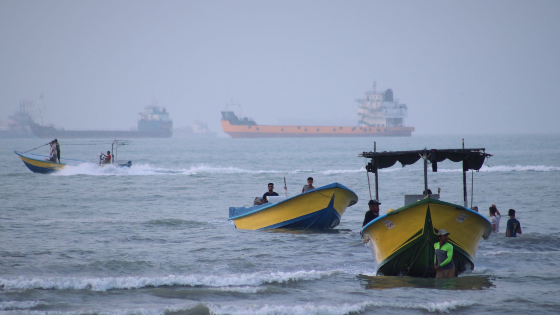 Small boats line the shore as cargo ships and other commercial vessels appear anchored in the Strait of Hormuz off Bandar Abbas on July 27. /Razieh Poudat/ISNA via AP
