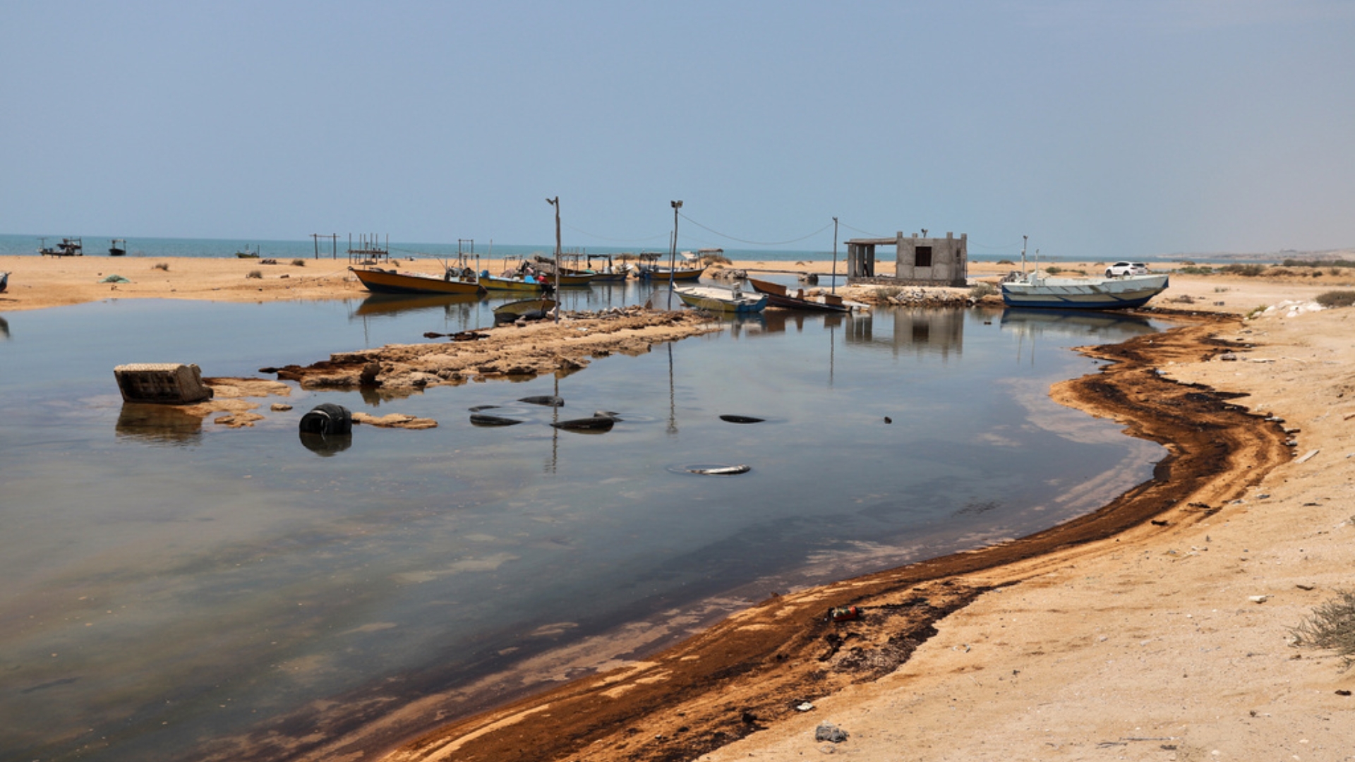 Oil residue lines the shore near fishing boats on Qeshm Island, Iran, Thursday, August 13, 2026. /Amirhosein Khorgooi/ISNA via AP