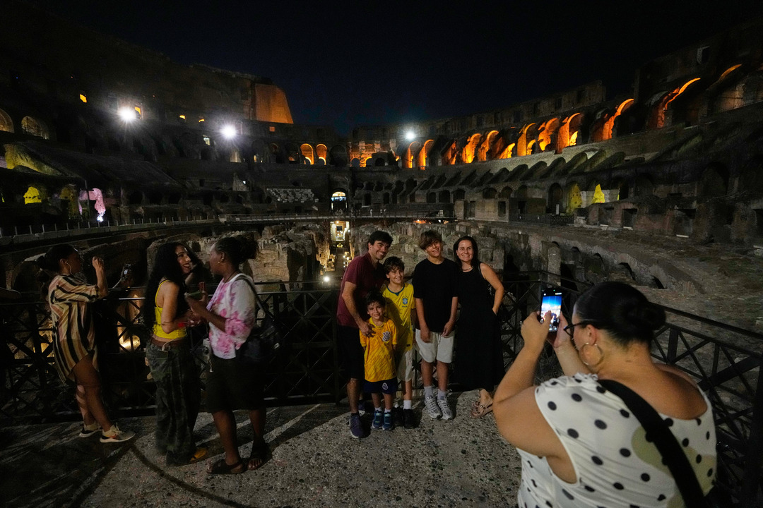 Tourists visit Rome's Colosseum during a special evening opening aimed at helping visitors avoid the daytime heat. /Gregorio Borgia/AP Photo