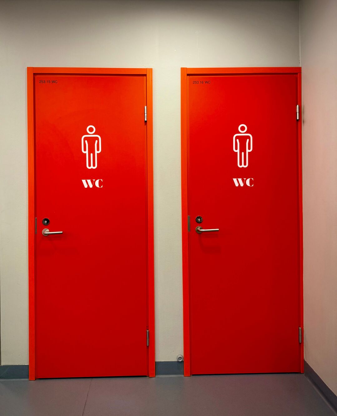 Two bold red restroom doors indoors marked with WC symbols. /Pexels  