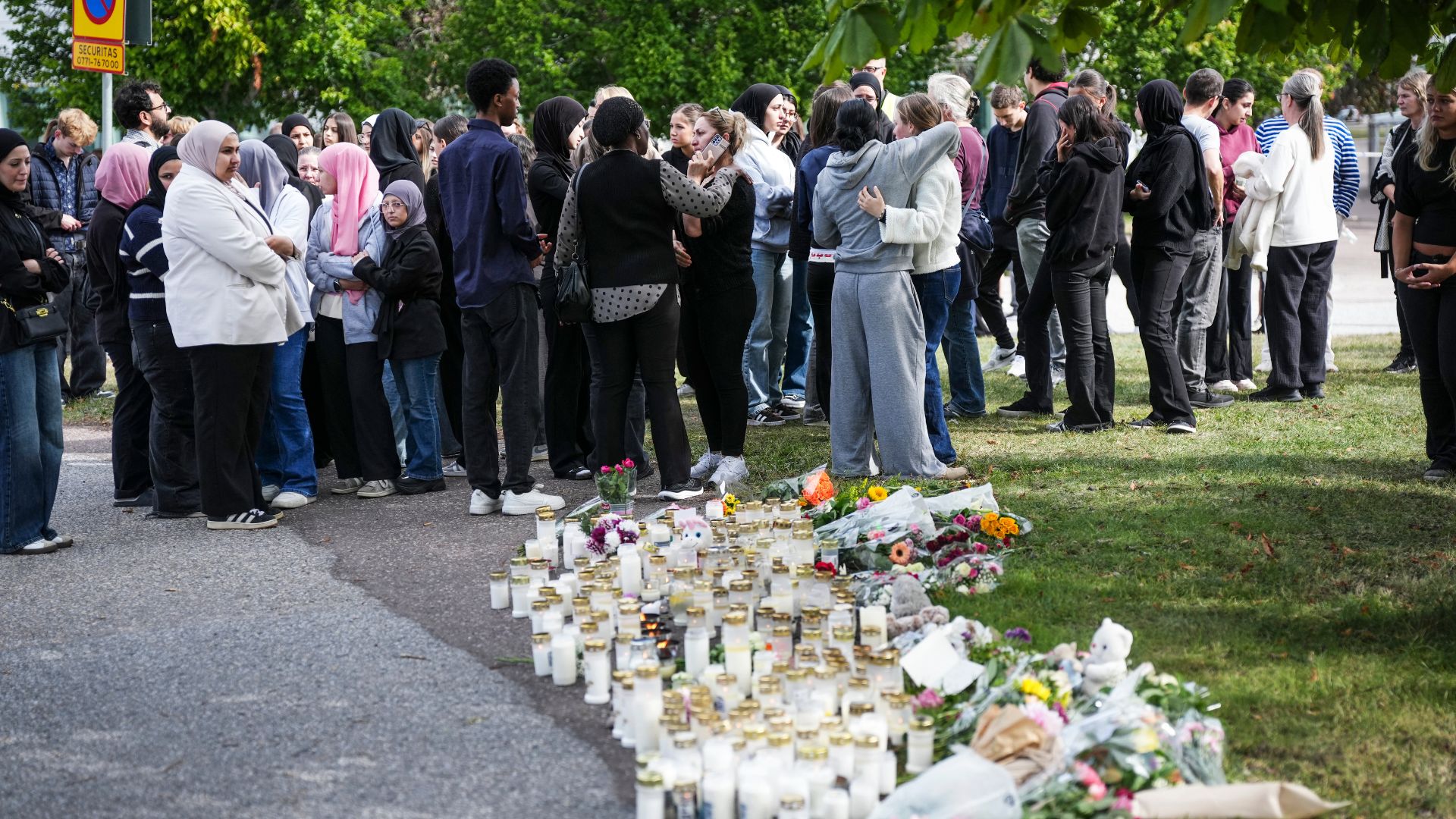 Residents leave flowers and candles at a makeshift memorial outside the school. /Magnus Lejhall/ TT News Agency/AFP