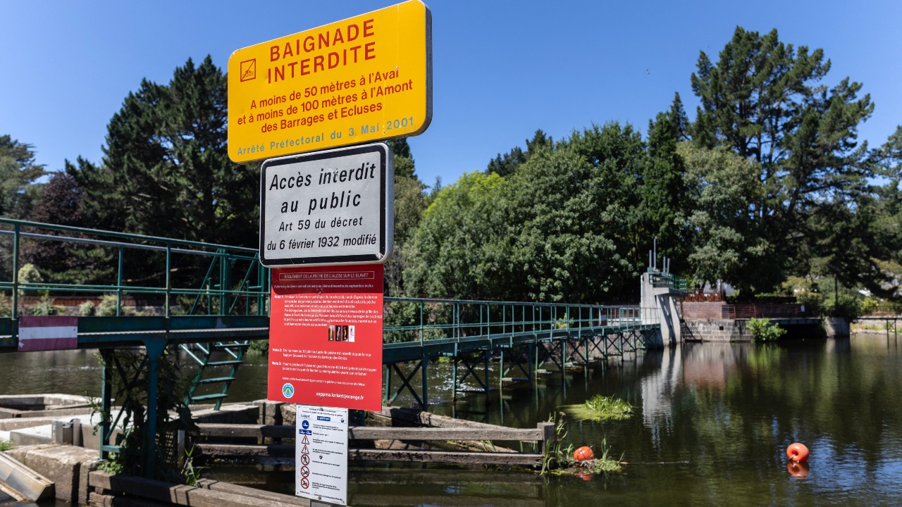 A warning sign saying 'Swimming forbidden' near a lock on the River Blavet at Hennebont, western France. /Fred Tanneau/AFP