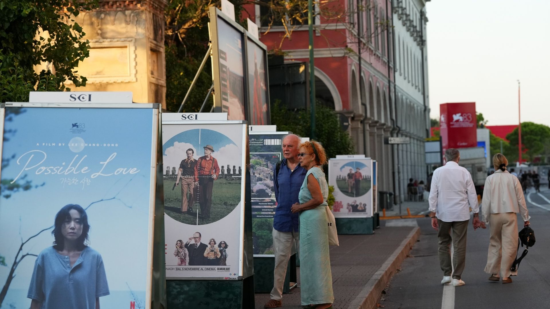 Onlookers analyze indie film posters prior to the 83rd edition of the Venice Film Festival in Venice, Italy. /Alessandra Tarantino/Invision/AP