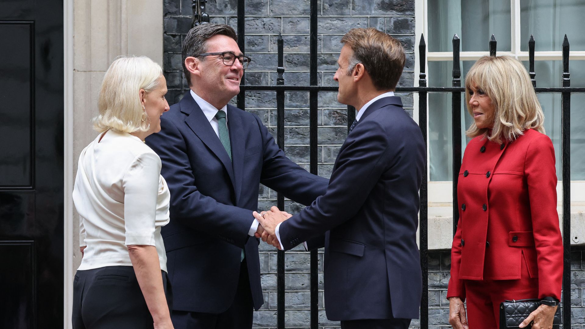 With his wife Marie-France van Heel (L), Britain's Prime Minister Andy Burnham (2L) welcomes France's President Emmanuel Macron (2R) and his wife Brigitte Macron (R) to 10 Downing Street in central London. /Ludovic Marin/AFP