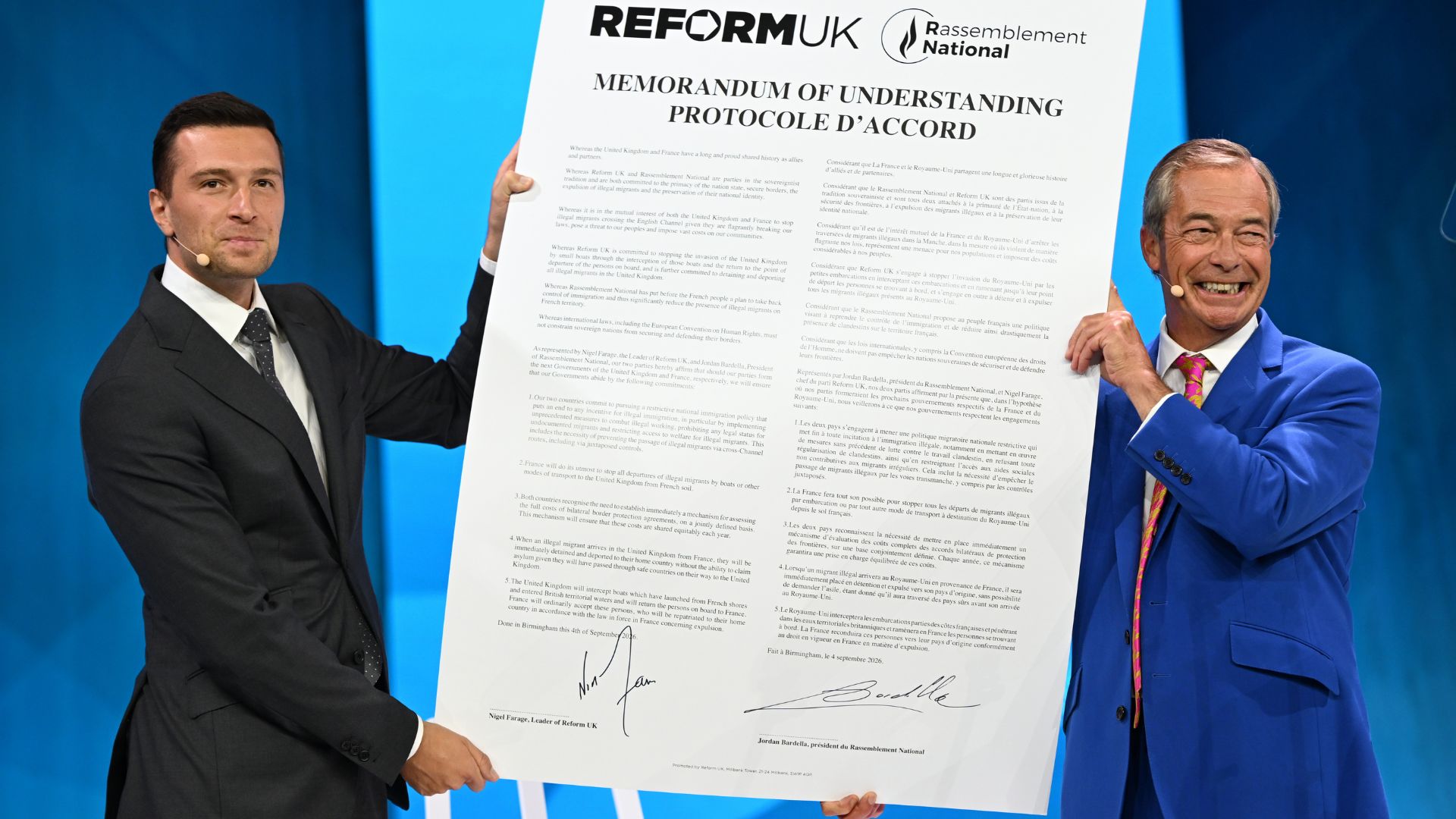French politician Jordan Bardella, President of Rassemblement National (RN), and Reform Party Leader Nigel Farage, sign an immigration agreement at the Reform annual party conference. /AP.