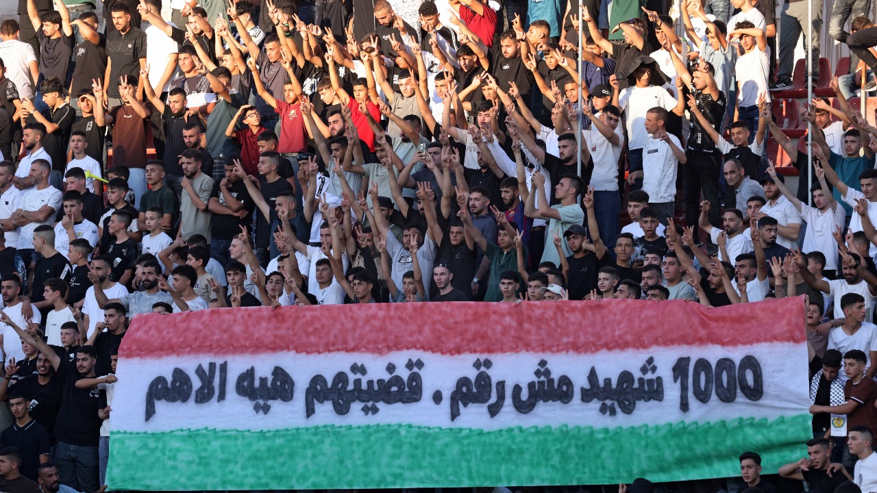 Enjoying the football match between Jabal Al-Mukaber and Shabab Al-Khalil in the 'Thousand Martyrs' Cup' tournament in the West Bank city of Al-Ram, north of Jerusalem. /Ahmad Gharabli/AFP