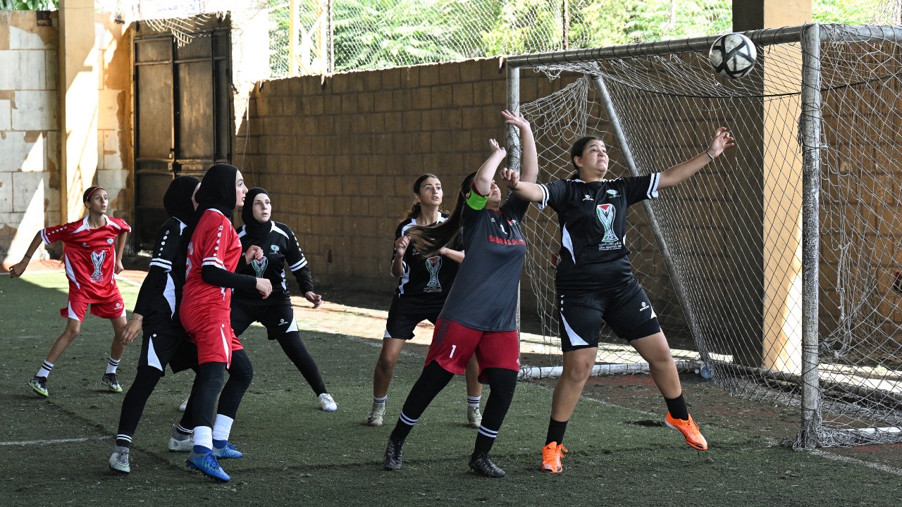 Palestinian refugee female football Tripoli team (in black) and Sidon team (in red) compete in the Palestinian Thousand Martyrs' Cup tournament in the southern Lebanese coastal city of Sidon./ Joseph Eid/AFP