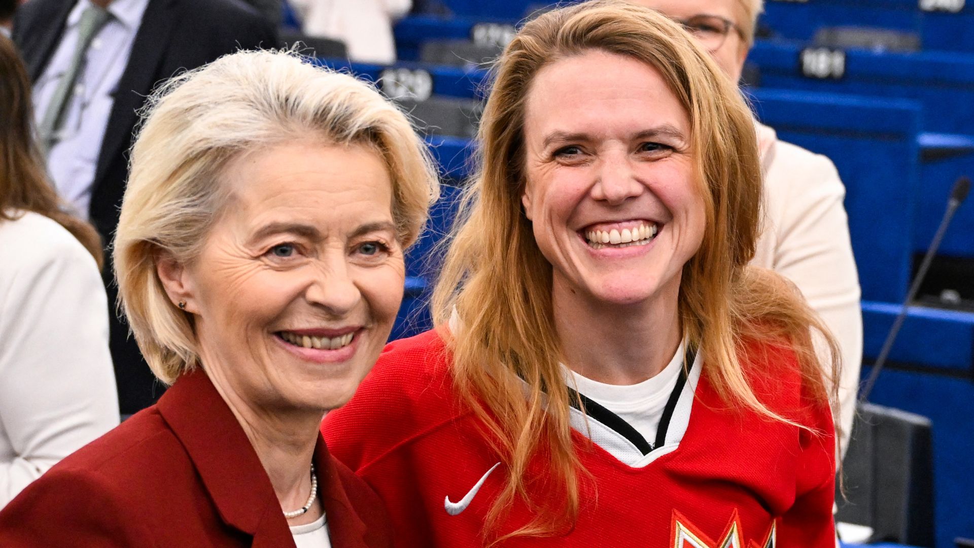 Greens/EFA group leader Terry Reintke (R) poses in a Candian ice hockey top with Von der Leyen at the Strasbourg speech. /Jean-Christophe Verhaegen/AFP
