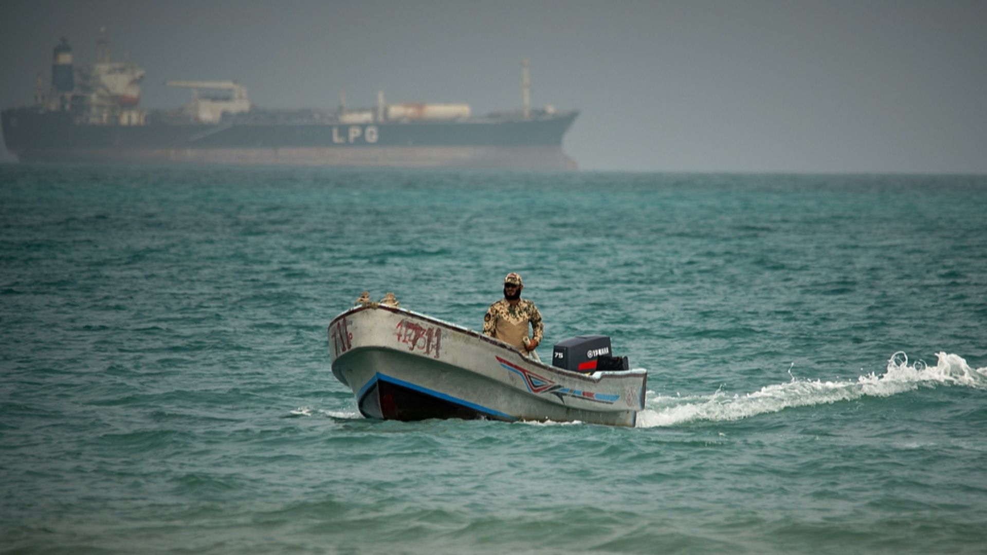 Backdropped by an LPG (liquefied petroleum gas) tanker, a Yemeni soldier sails in waters north of the Bab al-Mandeb Strait in Mokha, Yemen. /VCG