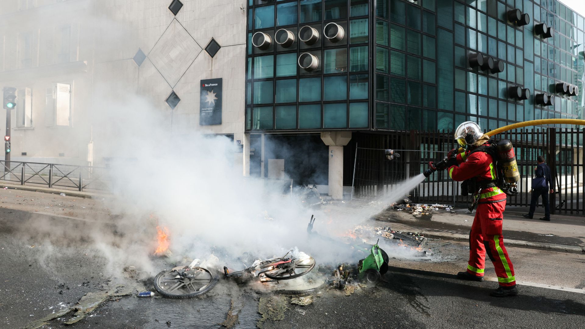 A firefighter extinguishes a fire as protesting students carry out blockading action at the Galilee vocation school, in Paris, on Friday. /Thomas Samson/AFP
