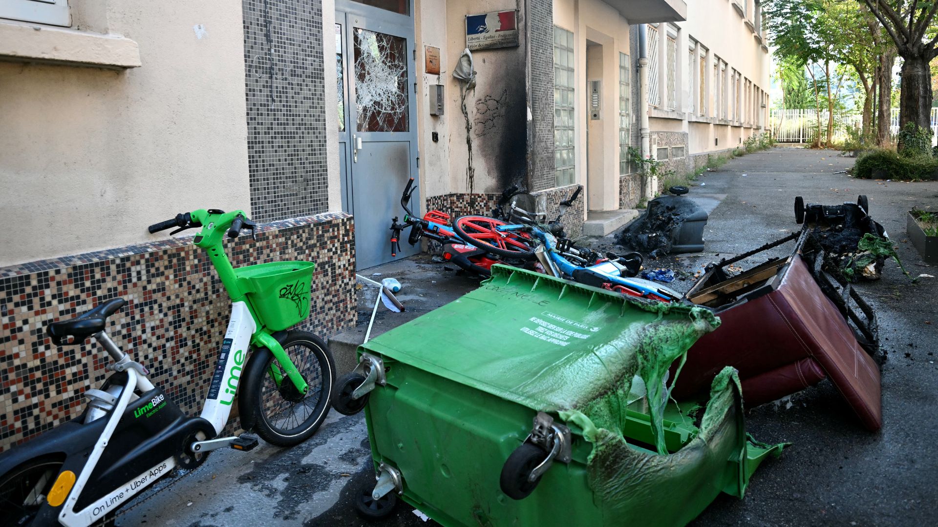 Burnt-out bins, furniture and bicycles in front of the damaged entrance to the Nicolas Louis Vauquelin vocational secondary school in Paris on October 5. /Lou Benoist/AFP
