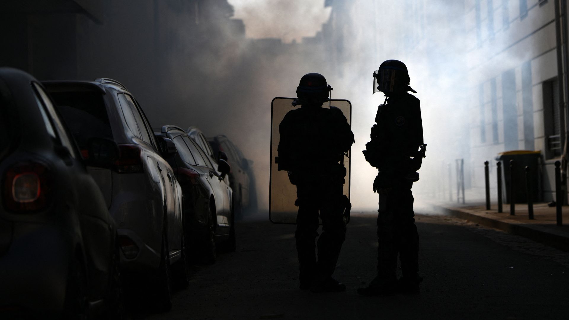 Riot police stand amid tear gas smoke during clashes with protesters on the sidelines of a demonstration of high-school students in Lyon, on October 6. /Olivier Chassignole/AFP
