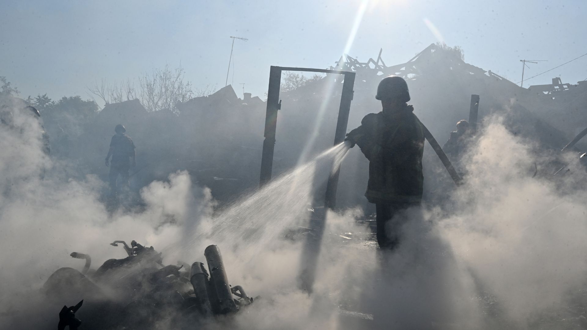 A firefighter extinguishes a fire in private houses following a Russian guided aerial bomb attack that killed one person, amid the Russian invasion of Ukraine, in Kharkiv on October 11. /Sergey Bobok/AFP

