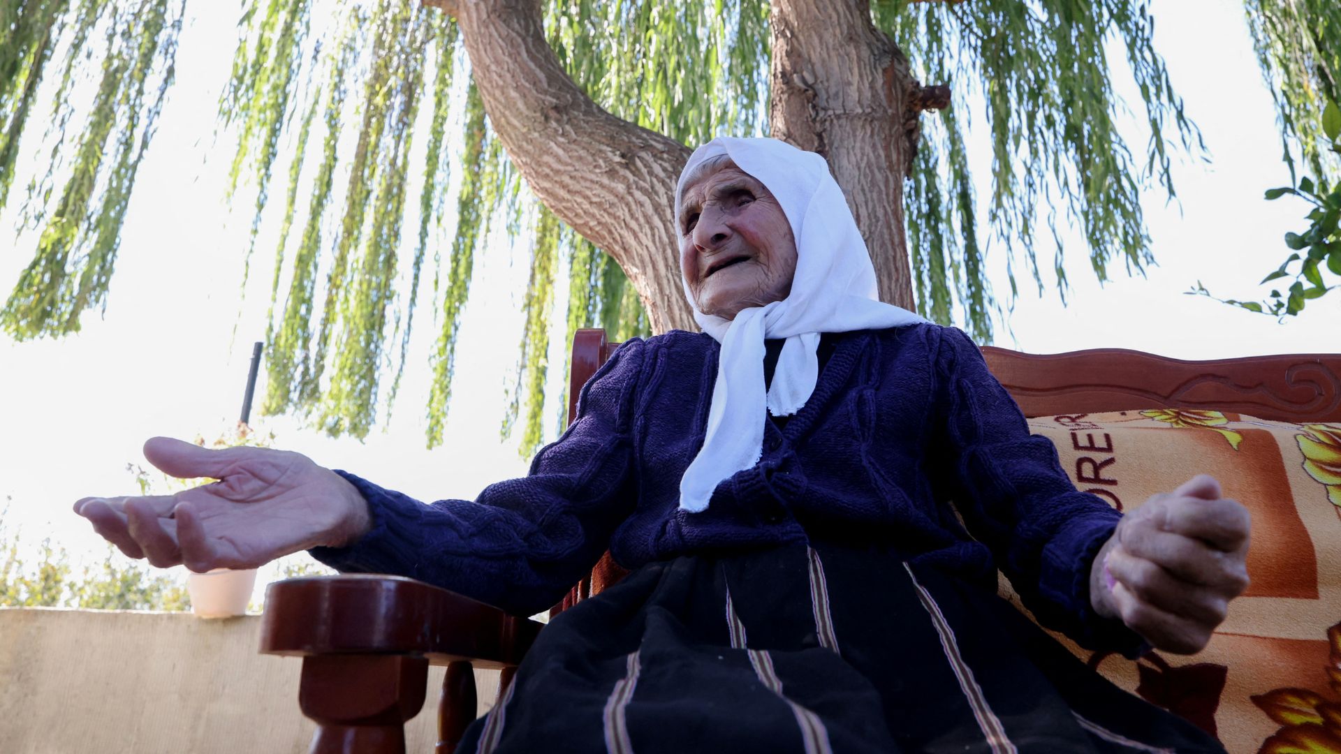 The 117-year-old Qamile Marra in her garden at Ferras, near Kucove, in Albania. /Adnan Beci/AFP
