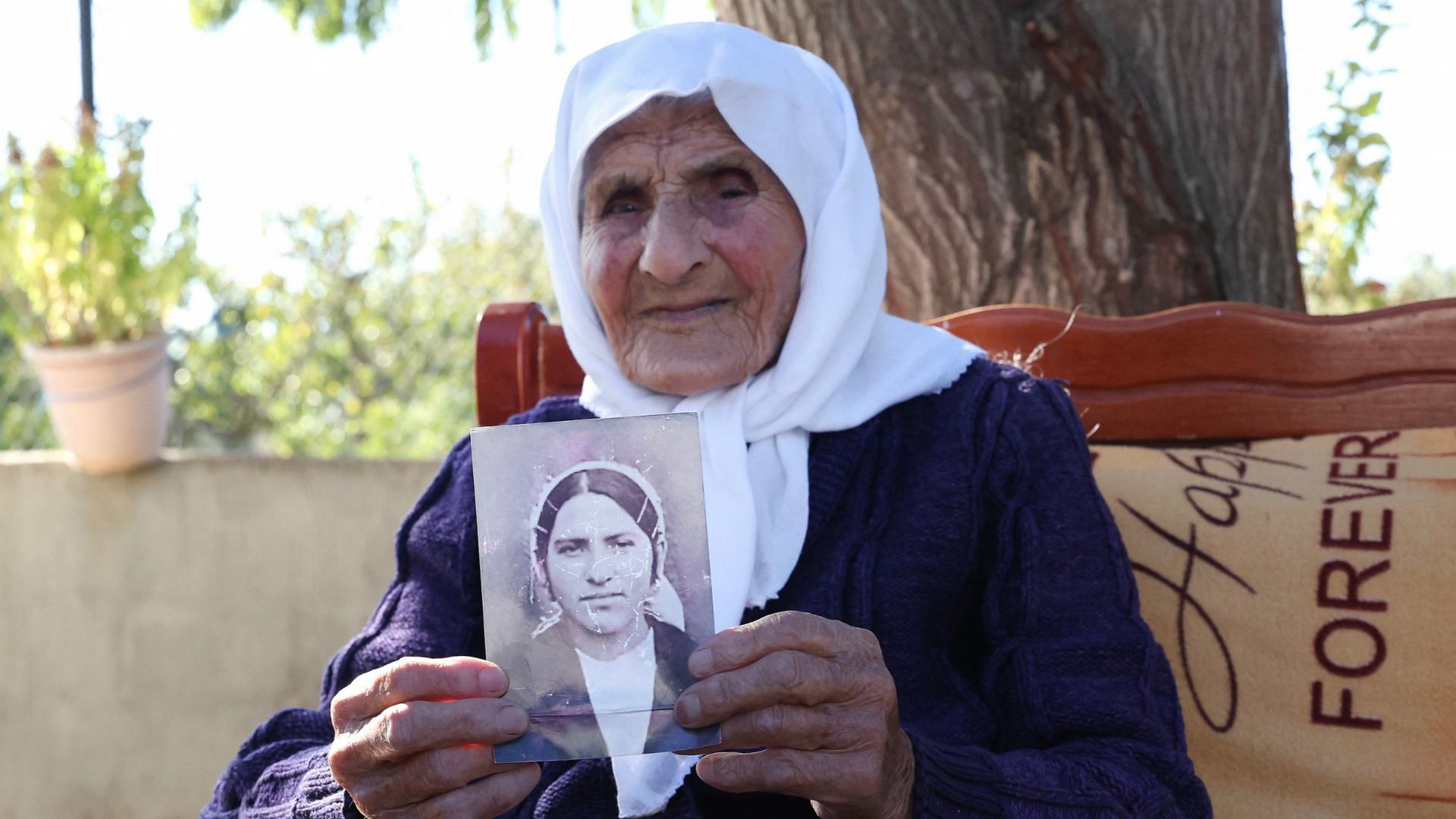 Marra holds a black and white photograph from her youth. /Adnan Beci/AFP