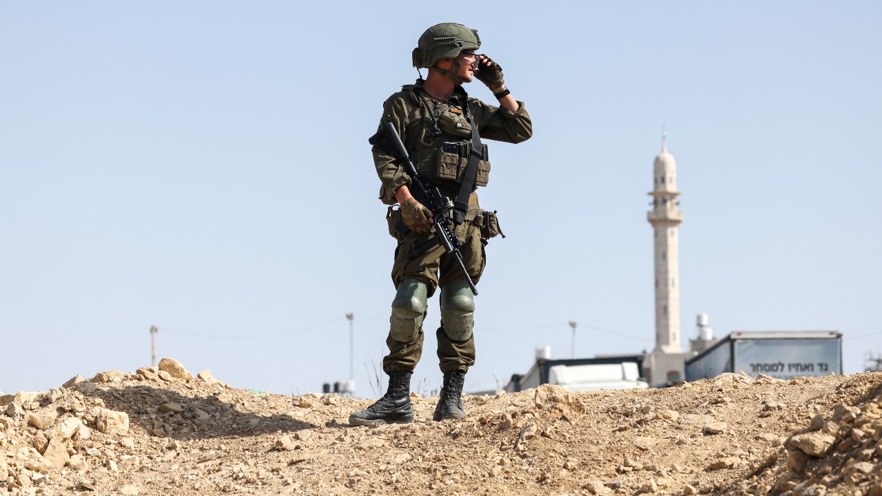 An Israeli soldier looks on at the scene of an earlier fire exchange between armed Palestinians and Israeli forces following an incident at the northern checkpoint of Hebron in the Israeli-occupied West Bank. /Ahmad GHARABLI / AFP