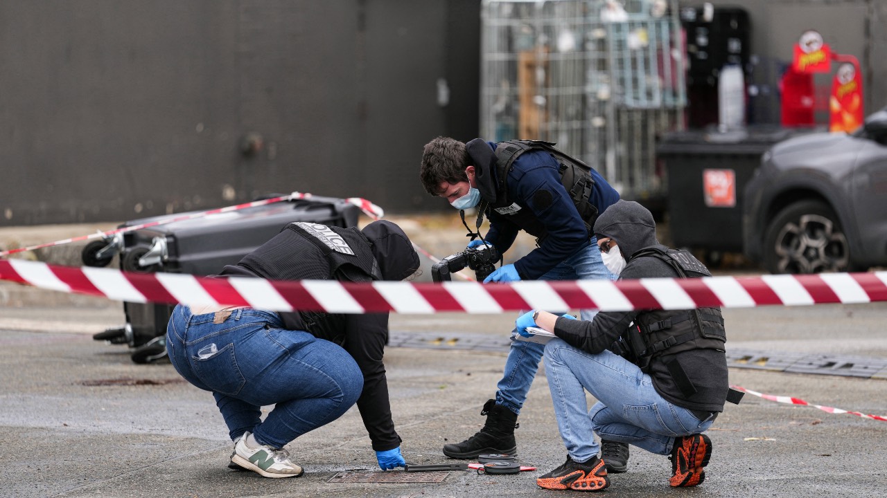 Forensic police look at evidences on a site of a petrol station where a man opened fire from his car, killing one person and injuring four others according to police sources, in Trappes, Paris' suburb. /Dimitar Dilkoff/AFP